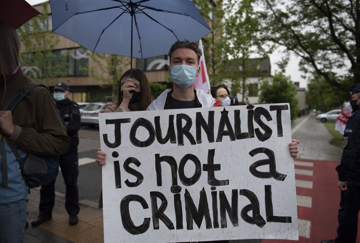 Protesta akcijas dalībnieks ar plakātu &quot;Žurnālists nav noziedznieks&quot;