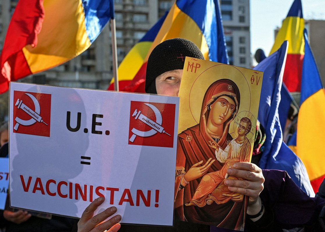 Rumānijas mūķene protestē pret vakcināciju ar plakātu, kas vēsta &quot;Eiropas Savienība=Vakcinistān...