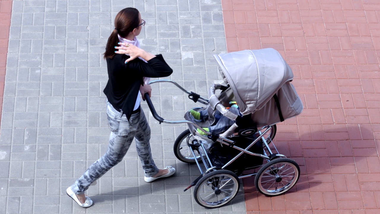 Sieviete ar bērnu ratiņiem dodas pilsētas ielās. Attēls ilustratīvs.