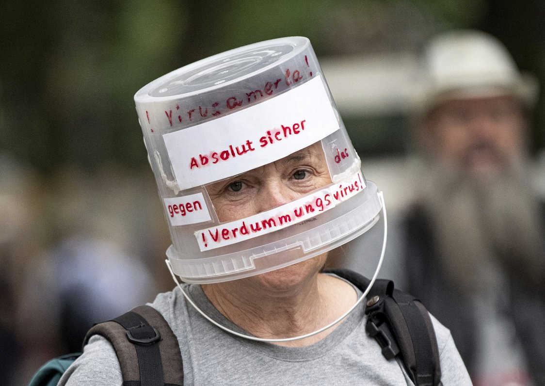Protesta akcijas dalībniece ar plastmasas spainīti galvā vēršas pret &quot;stulbuma vīrusu&quot;