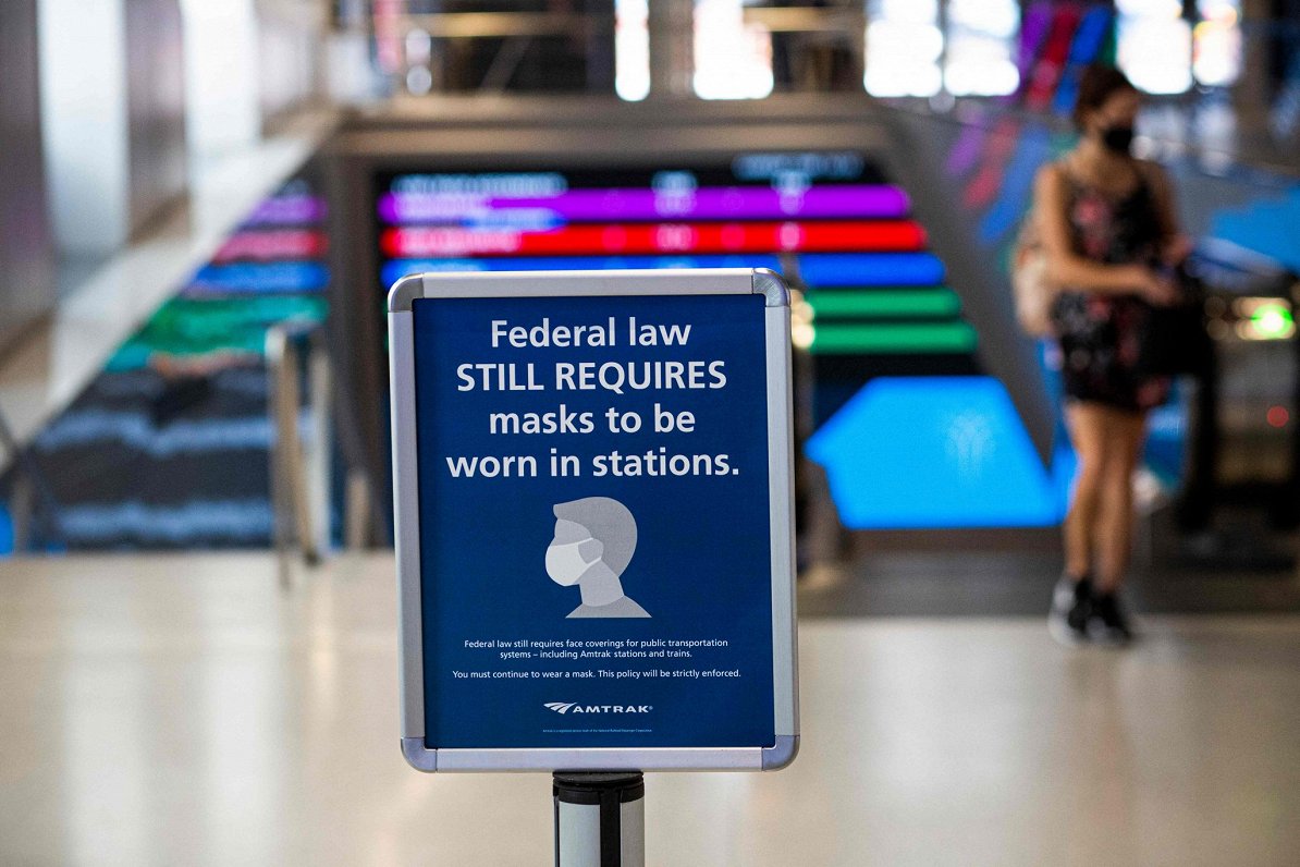 Ņujorkas dzelzceļa stacijā brīdinājums vēsta, ka likums joprojām pieprasa stacijā lietot sejas masku...