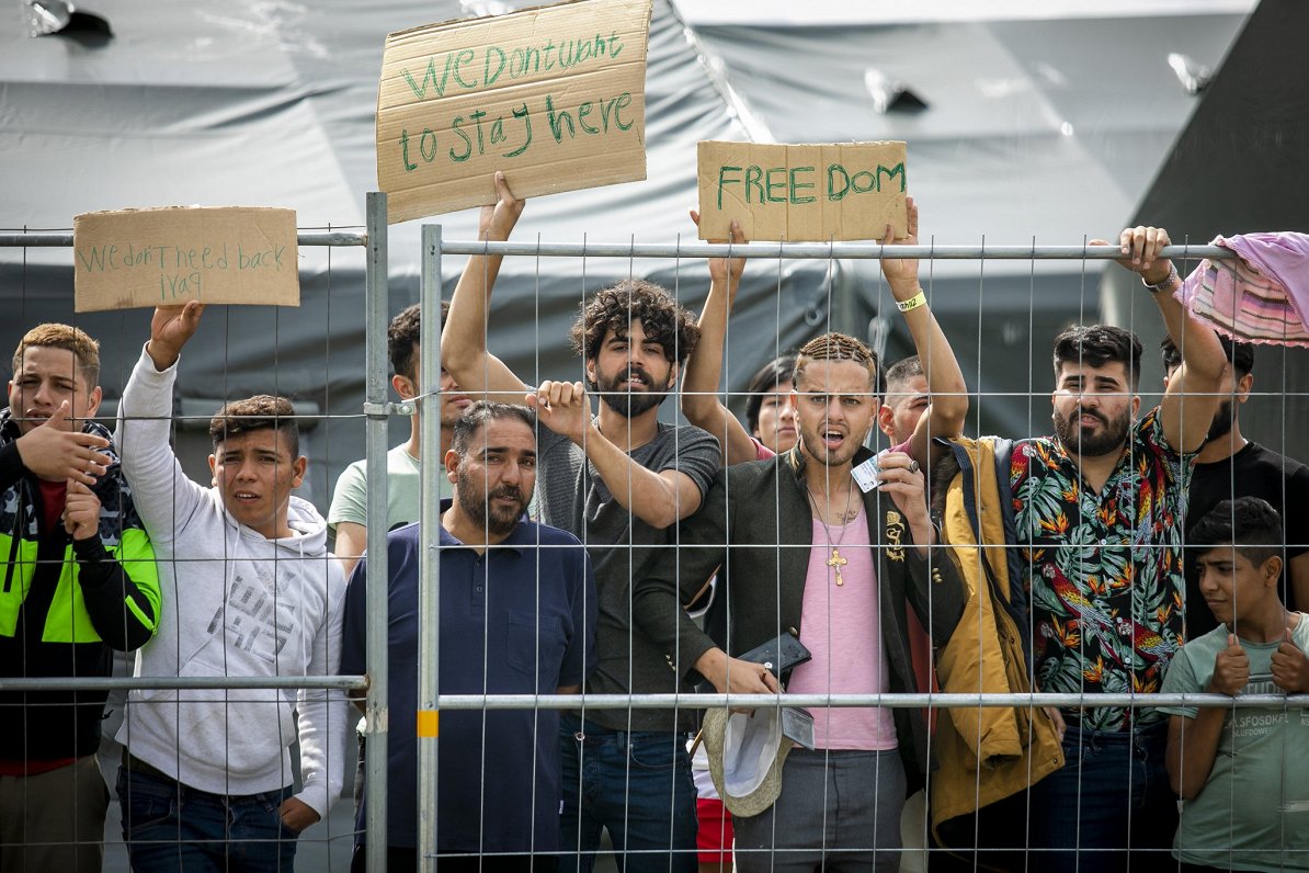 Lietuvas nometnē ievietotie migranti ar plakātiem &quot;Mēs negribam šeit palikt&quot; un &quot;Brīv...