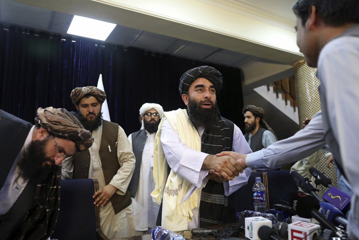 &quot;Taliban&quot; runasvīrs Zabihulla Mudžahīds pēc preses konferences Kabulā spiež roku žurnālist...