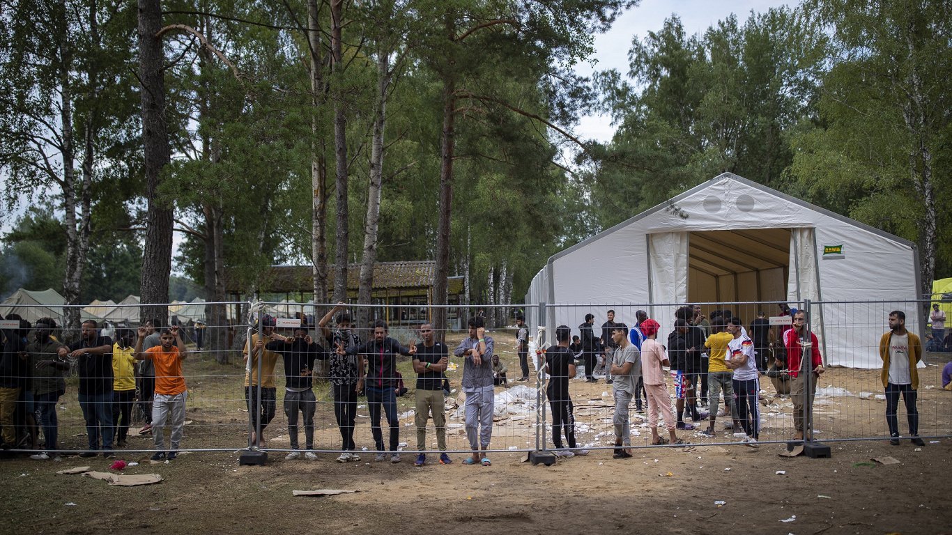 Мигранты у забора лагеря для беженцев на полигоне в Рудининкяе (Литва), август 2021-го