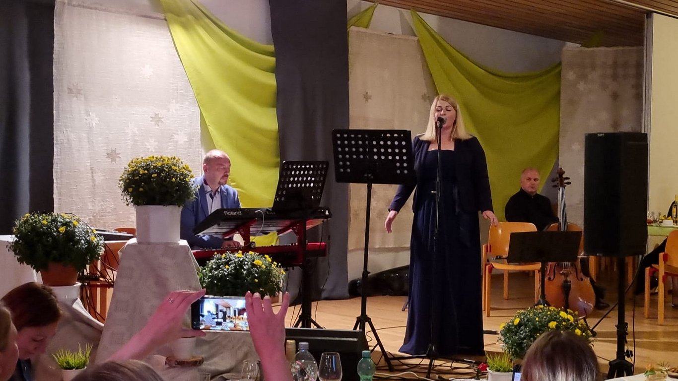 Pašas sacerēto dziesmu, veltījumu Latviešu centram Minsterē izpilda LCM latviešu kora “Dudan” diriģe...