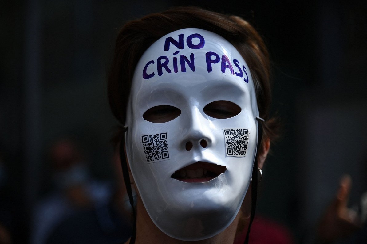 Protestētājs ar masku, kas vēršas pret prasību uzrādīt Covid-19 sertifikātu jeb &quot;zaļo pasi&quot...