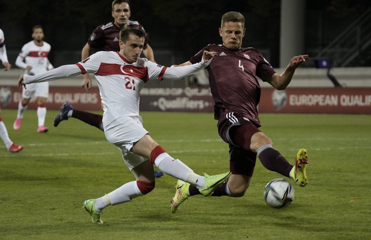 Kaspars Dubra (pa labi) cīņā pret Turcijas futbolistu Keremu Akturkoglu