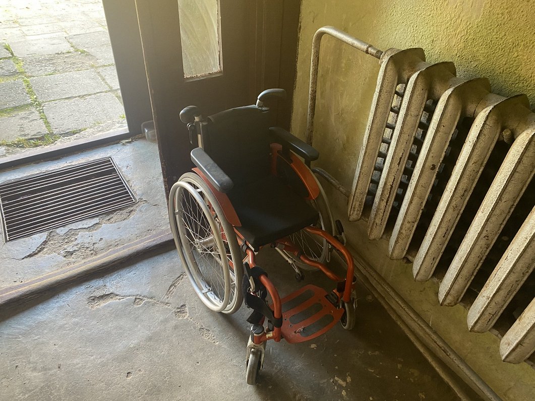 Kristas ratiņkrēsls daudzdzīvokļu nama kāpņu telpā.