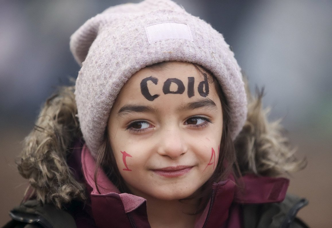 Migrantu meitene pie Baltkrievijas un Polijas robežas. Uzraksts uz sejas vēsta &quot;Auksti&quot;. A...