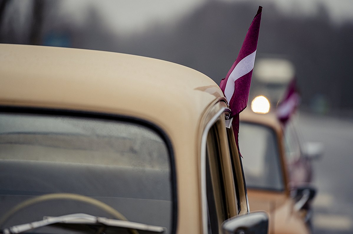 Automašīnas ar Latvijas karodziņiem.