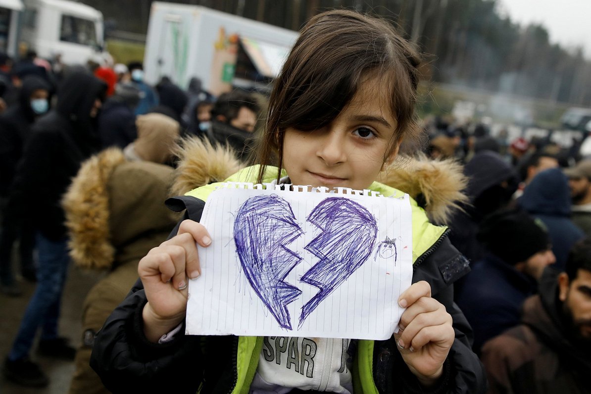 Migrantu nometnē pie Baltkrievijas un Polijas robežas meitene rāda savu zīmējumu