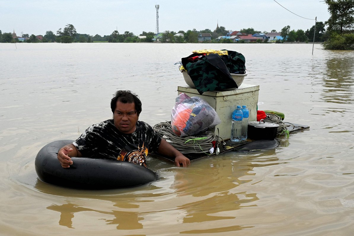 Vīrietis glābj savu iedzīvi pēc plūdiem Kambodžā