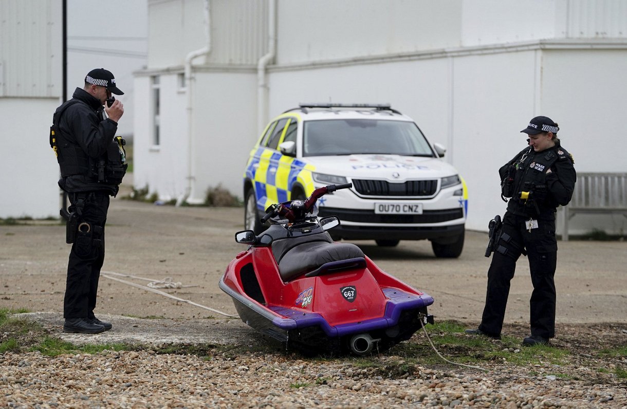 Britu policisti aplūko piekrastē pamestu ūdens motociklu, kas, iespējams, izmantots Lamanša šķērsoša...