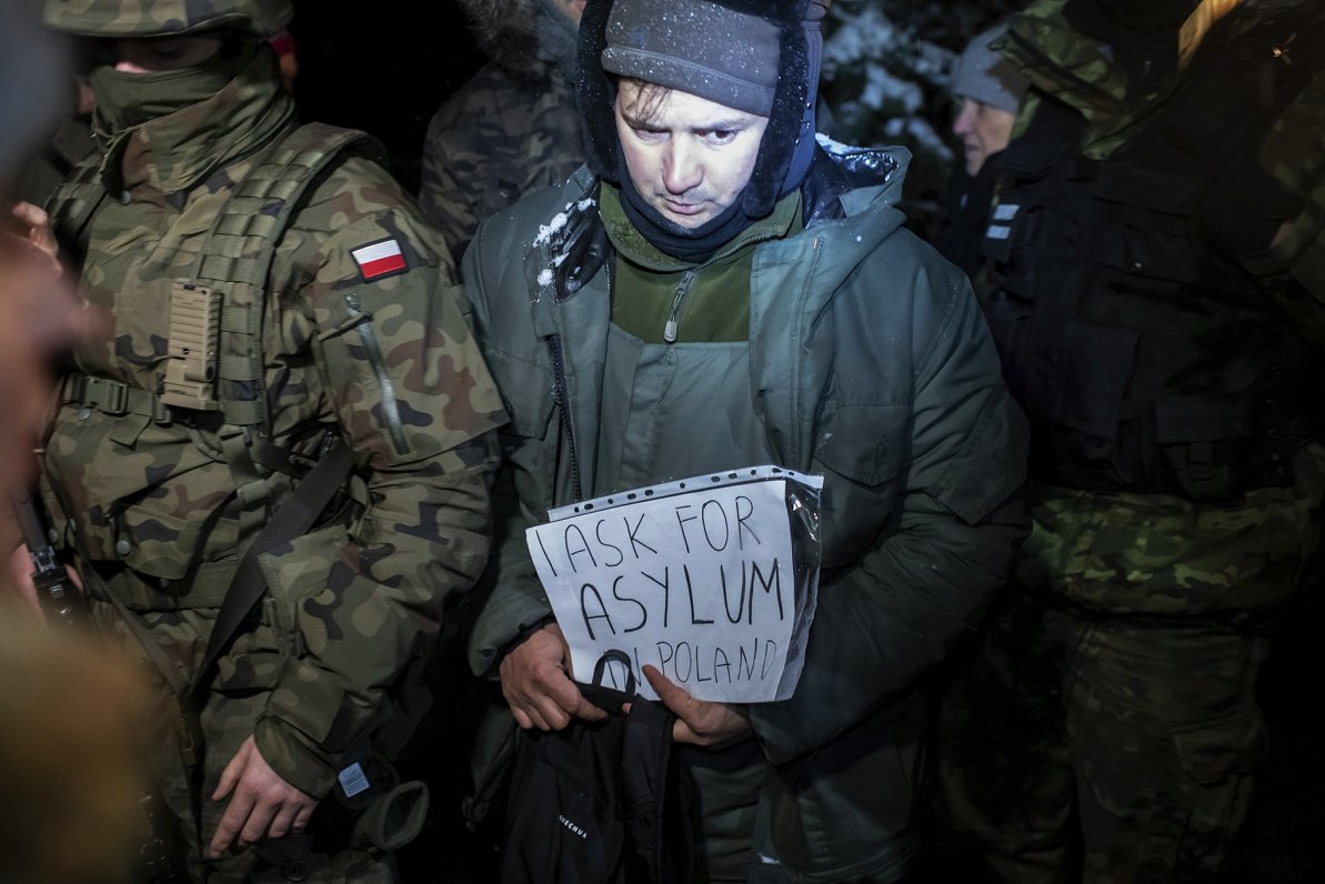 Sīriešu patvēruma meklētājs ar plakātu &quot;Es lūdzu patvērumu Polijā&quot;