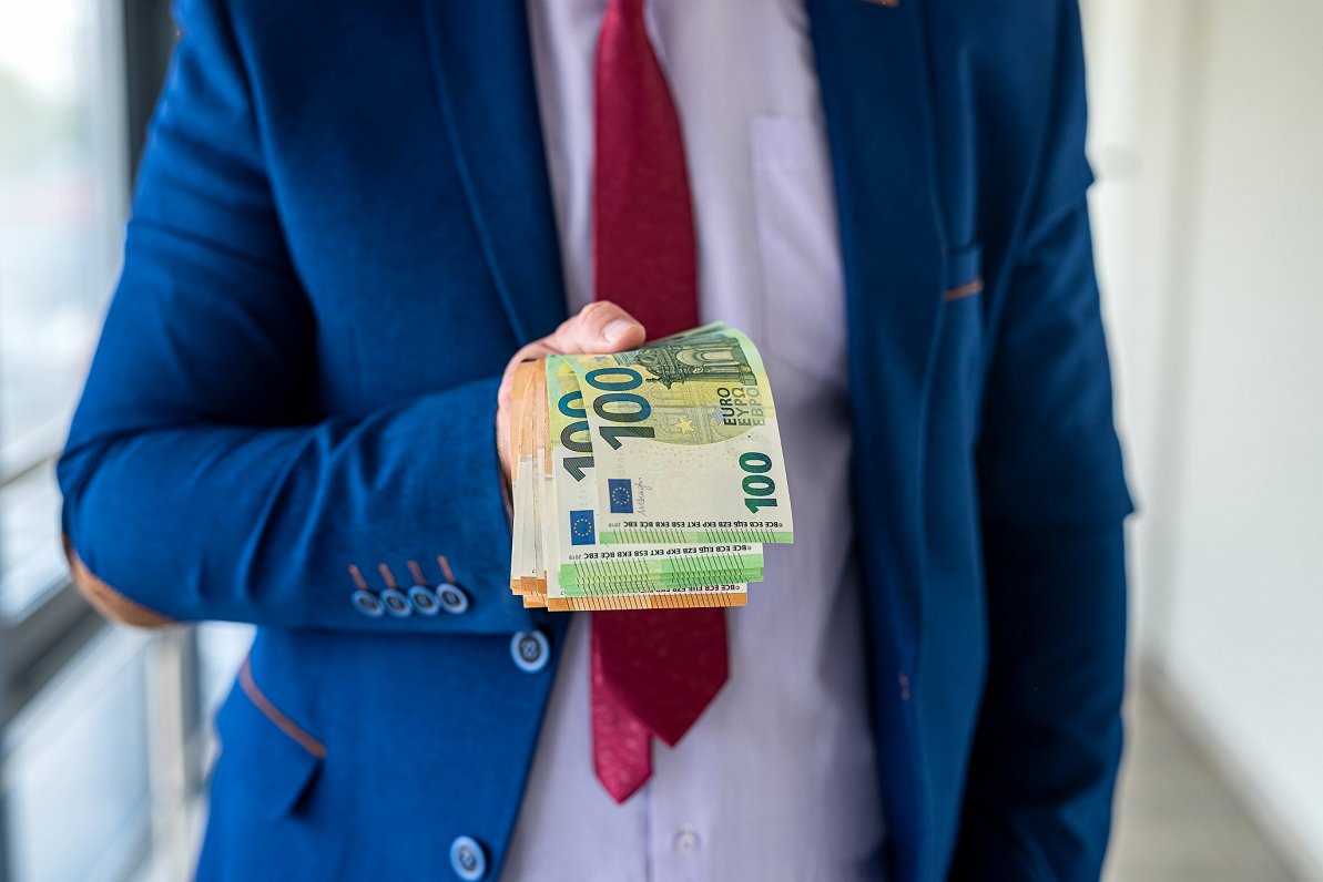 Cilvēks ar eiro naudas banknotēm.