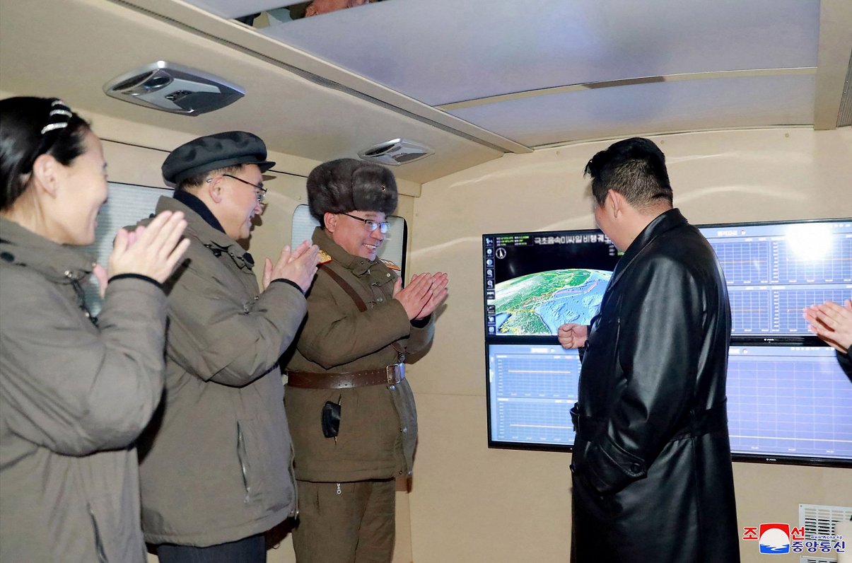 Ziemeļkorejas vadonis Kims Čen Uns (no labās) ar armijas vadību vēro jaunās raķetes izmēģināšanu