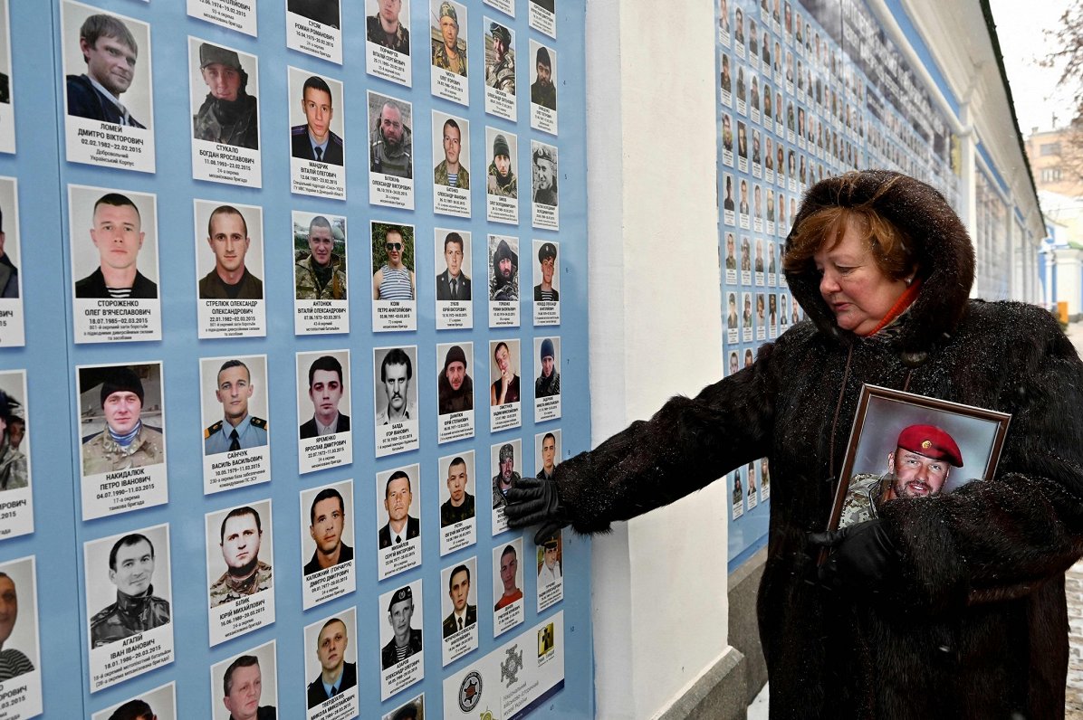 Cīņā ar Krievijas atbalstītajiem separātistiem kritušā Ukrainas karavīra māte pie piemiņas sienas ga...