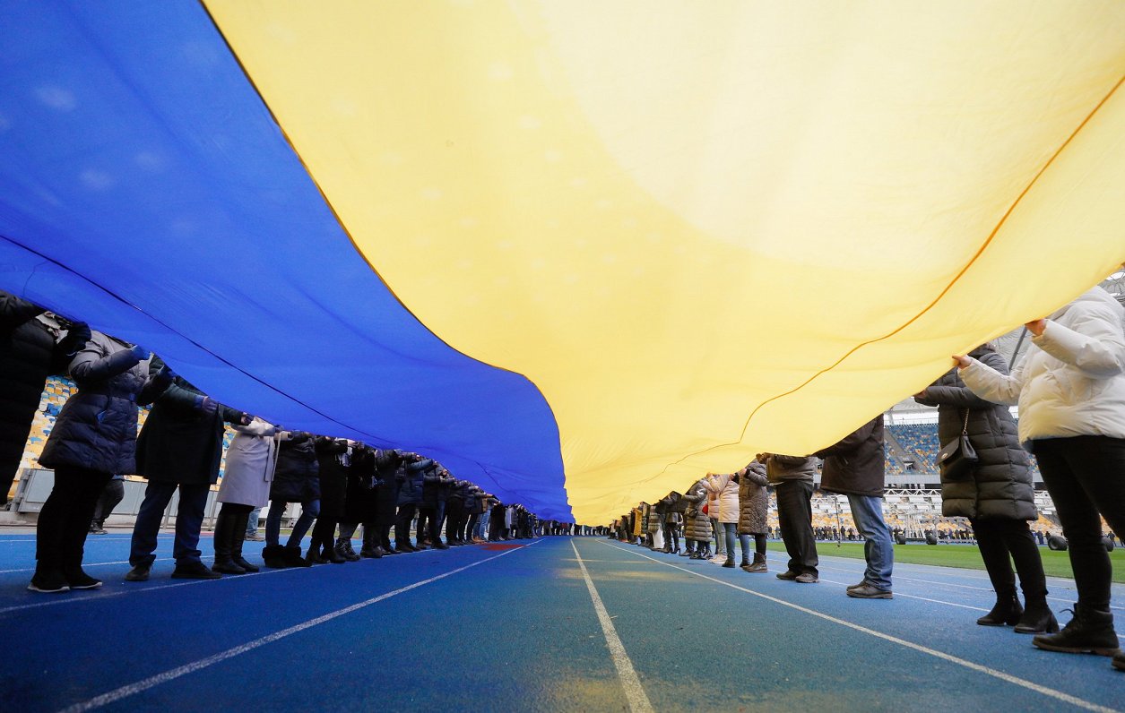 Kijevas Olimpiskajā stadionā trešdien ukraiņi izklāja milzīgu 200 metru garu valsts karogu, kas simb...