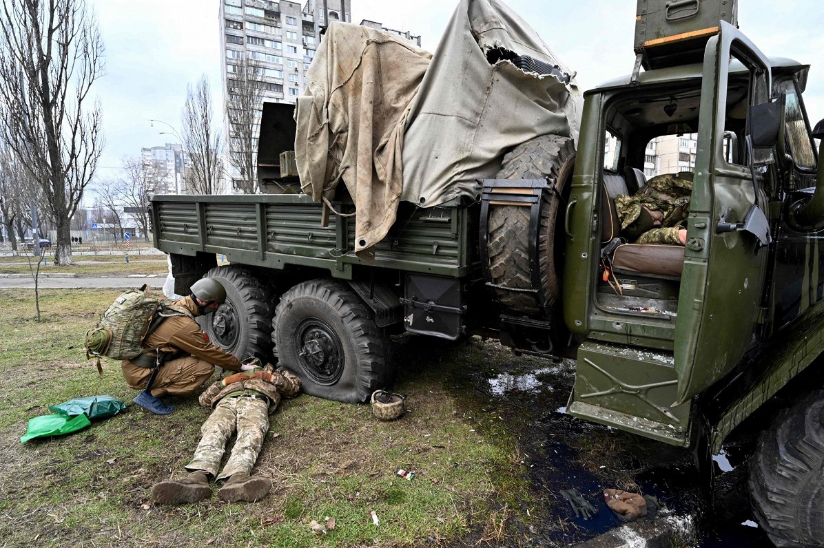 Украинский военный медик осматривает тело одного из членов российский разведывательно-диверсионной г...