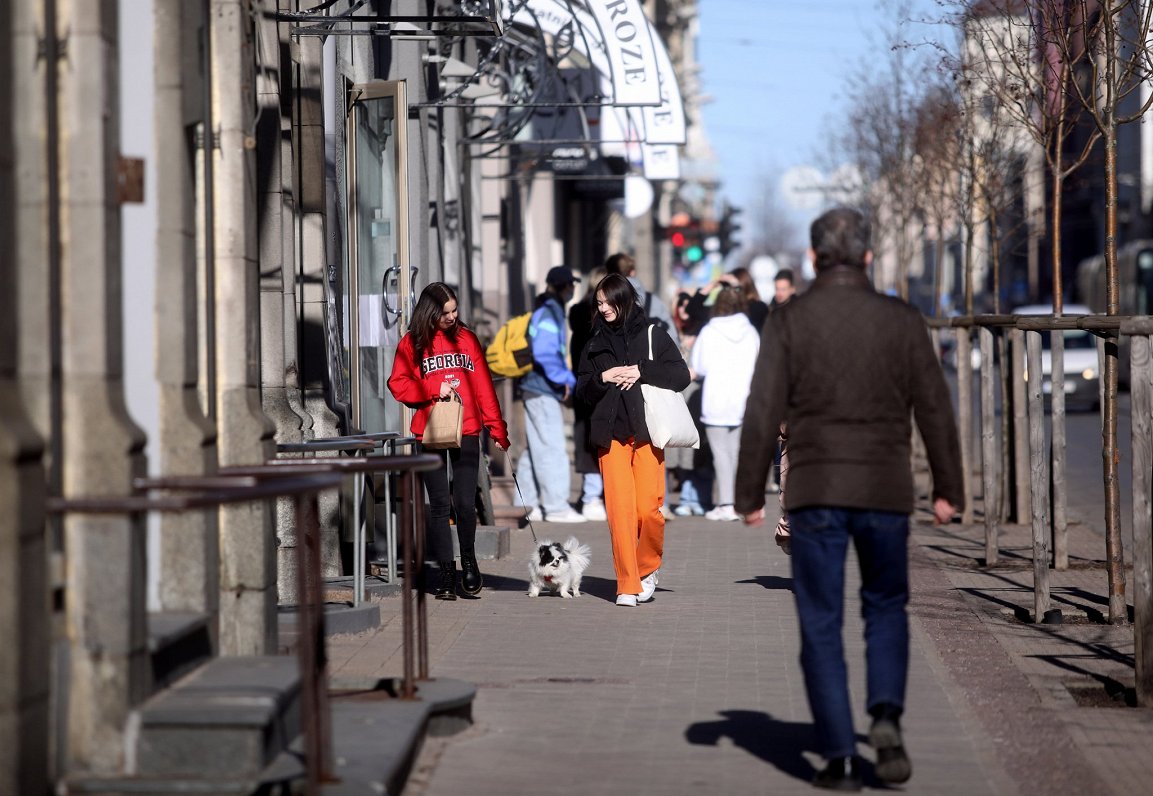 Cilvēki saulainā pavasara dienā Rīgas centrā.