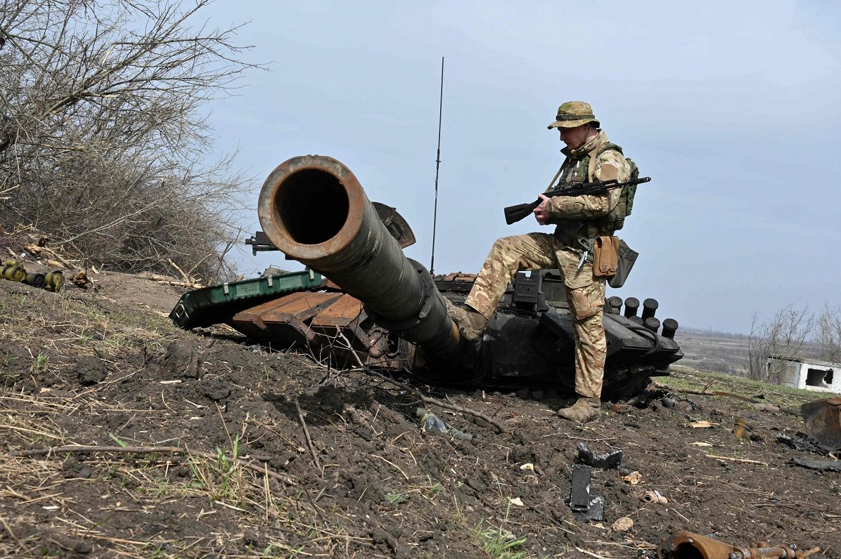 Ukrainas karavīrs pie iznīcināta Krievijas tanka Harkivas apgabalā