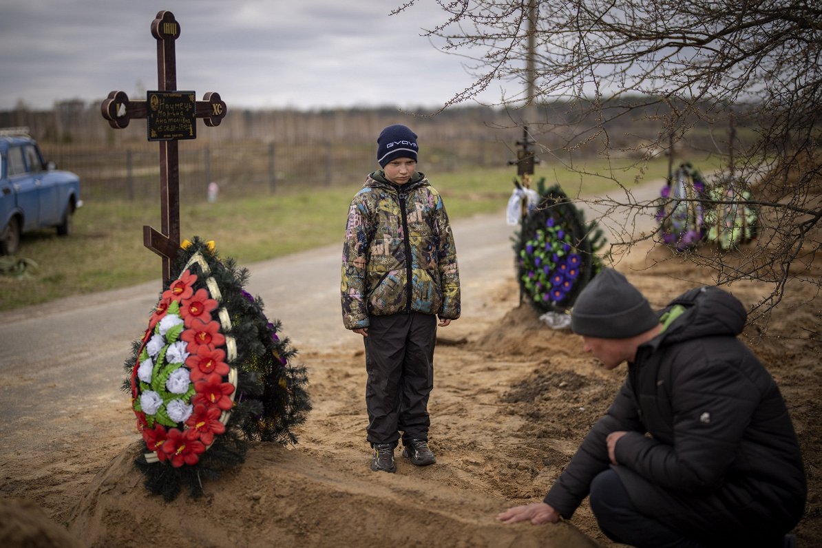 Ukrainas pilsētā Bučā desmit gadu vecais zēns Vova ar tēvu Ivanu sēro pie mammas Marinas kapa. Zēna...