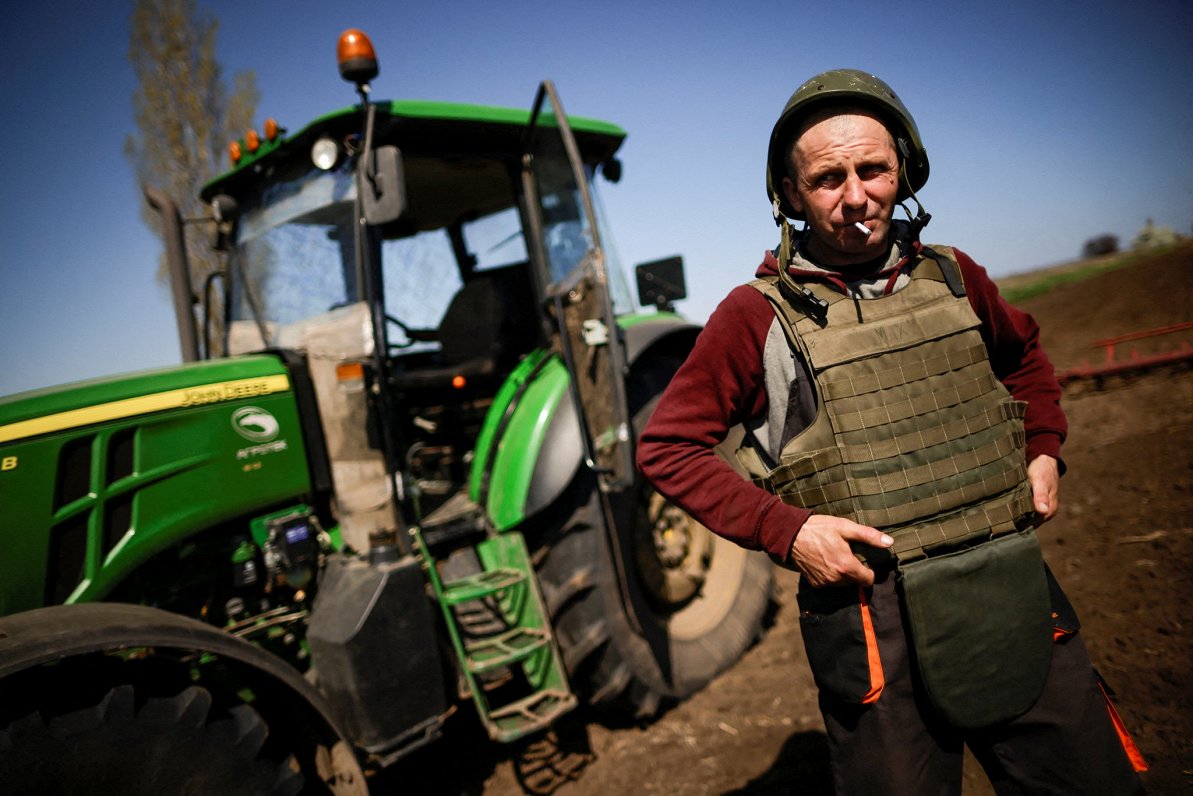 Ukrainas lauksaimnieks ar bruņu vesti aršanas darbos