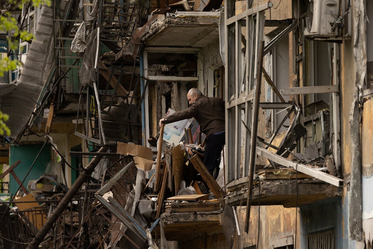 Человек на балконе жилого дома в Доброполье в Донецкой области. 30.04.2022