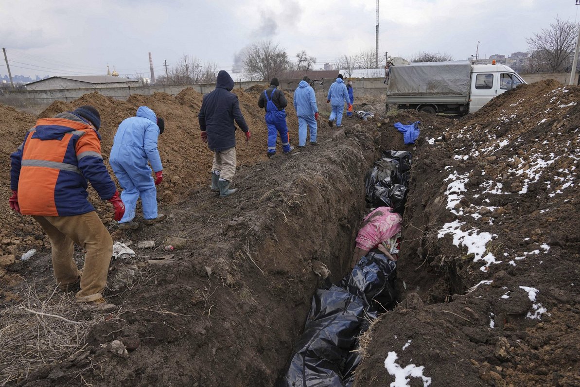 Krievijas uzbrukumā nogalināto civiliedzīvotāju apbedīšana masu kapā Mariupolē