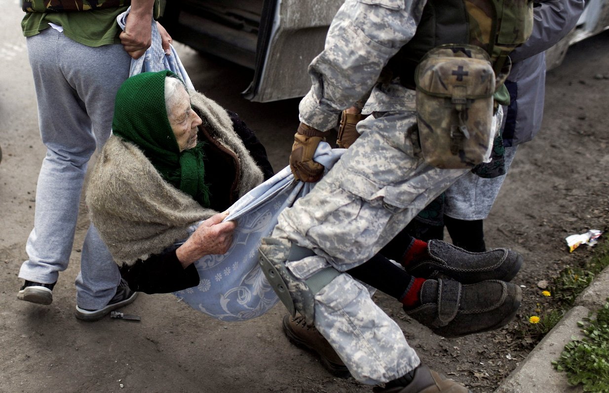 Волонтеры помогают женщине эвакуироваться из деревни у линии фронта. Харьковская область. 02.05.2022