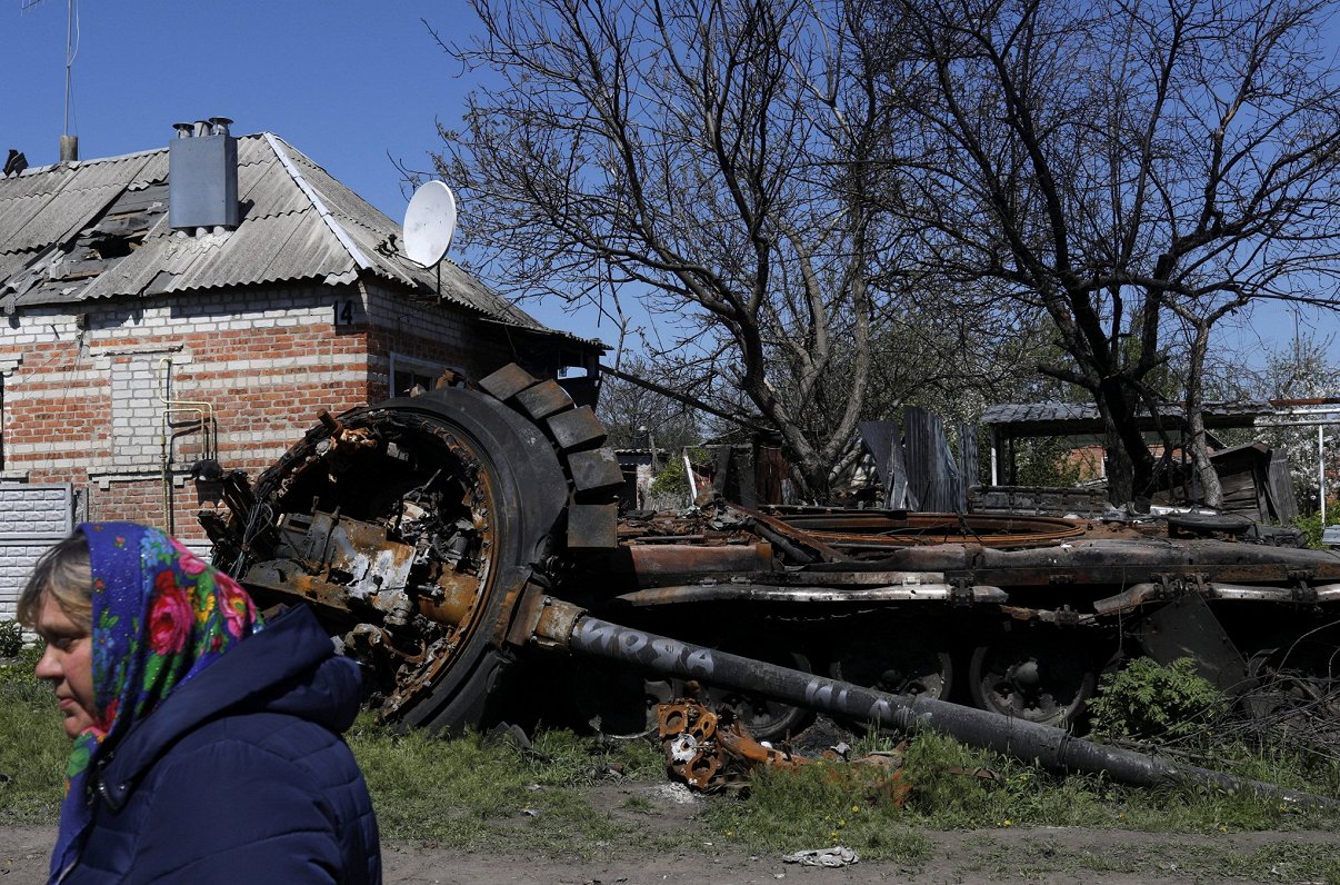 Женщина идет мимо уничтоженного танка. Малая Рогань, Харьковская область. 05.05.2022