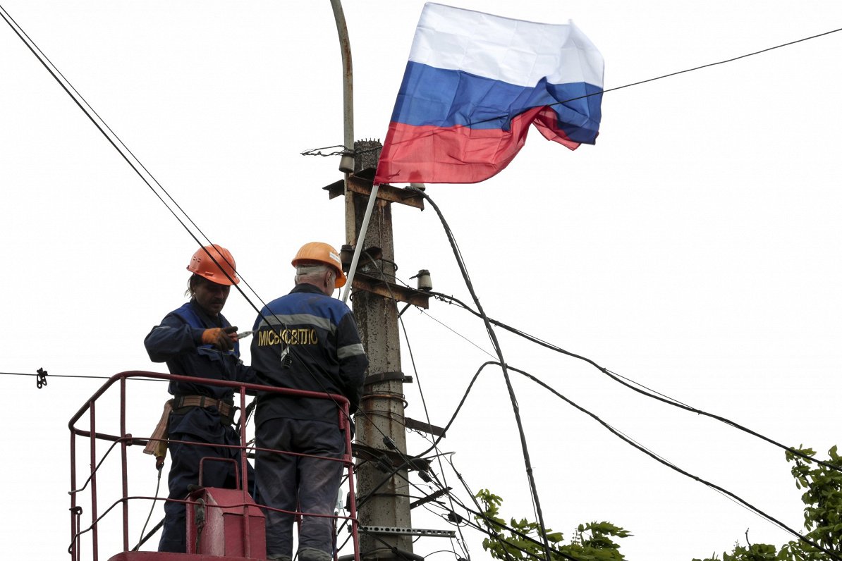 Ukrainas pilsētā Mariupolē, ko ieņēmis Krievijas karaspēks, strādnieki izkar Krievijas karogus