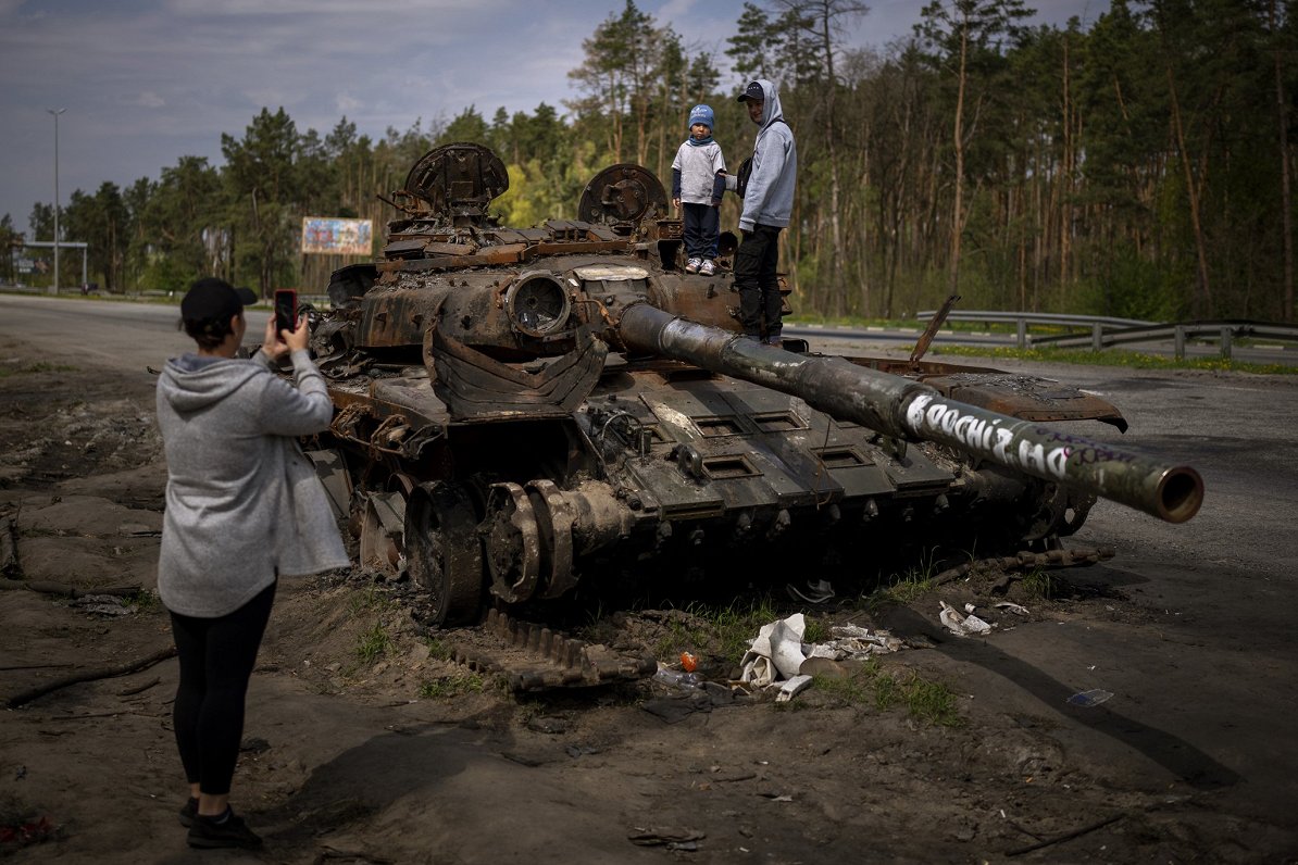 Дети фотографируются на башне уничтоженного российского танка. Пригороды Киева. 08.05.2022