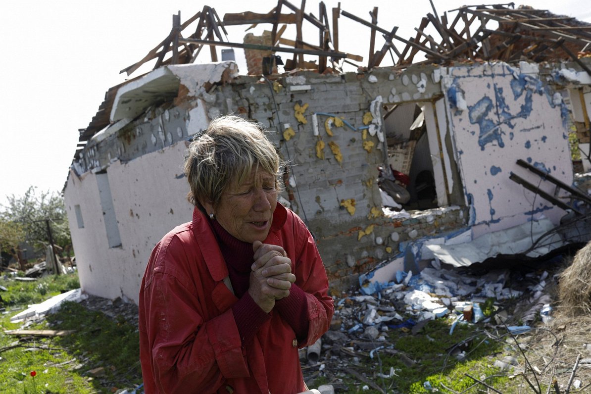 Ukrainas iedzīvotāja pie savas mājas, kas izpostīta Krievijas uzbrukumā