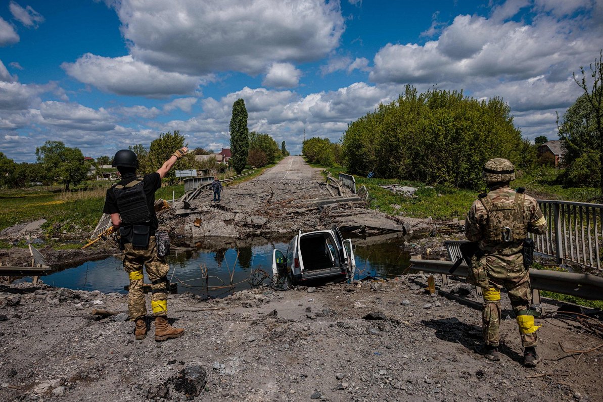 Ukraiņu karavīri pie uzspridzināta tilta.