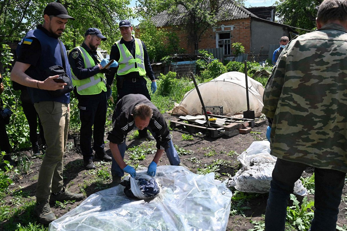 Līķa ekshumācija Mala Roganas ciemā Ukrainā. 2022. gada maijs.
