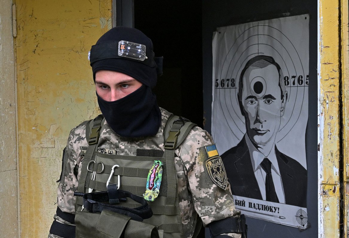 Ukrainas karavīrs pie šaušanas treniņu mērķa, kurā attēlots Krievijas prezidents Vladimirs Putins