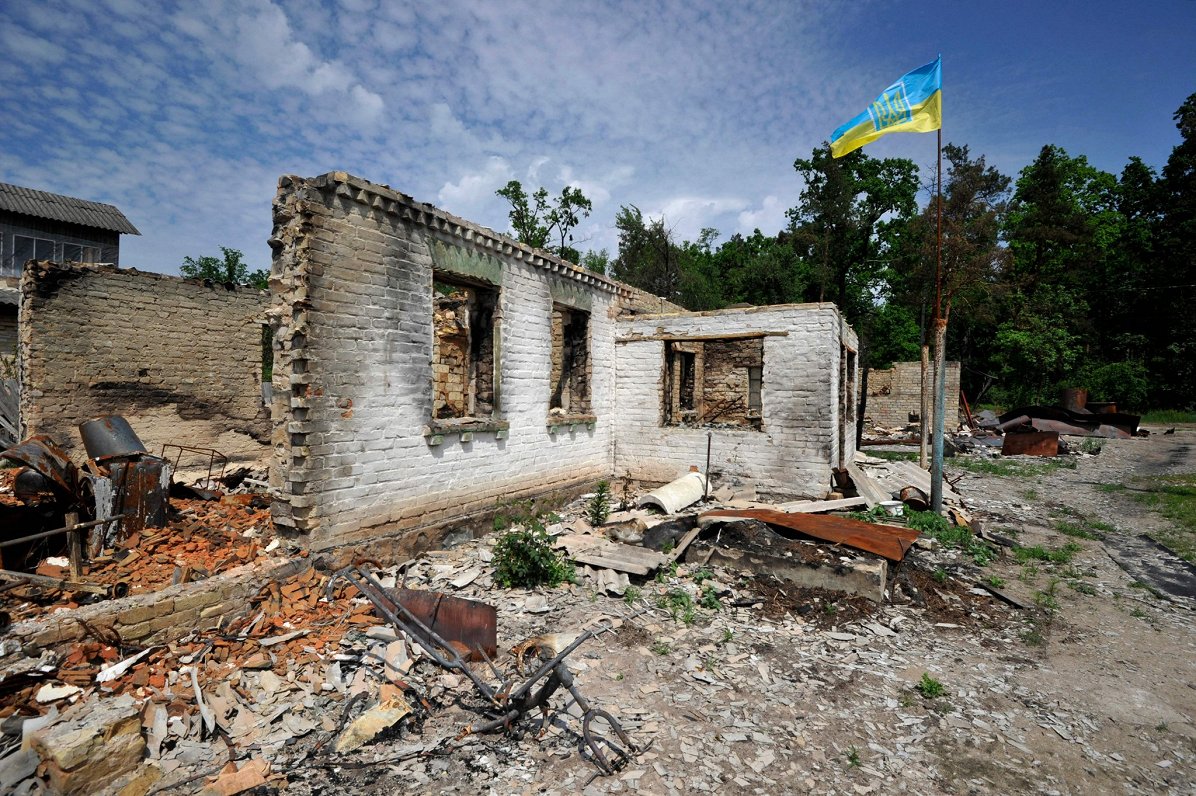 Ukrainas karogs plīvo pie karadarbībā izpostītas mājas Kijivas apgabalā