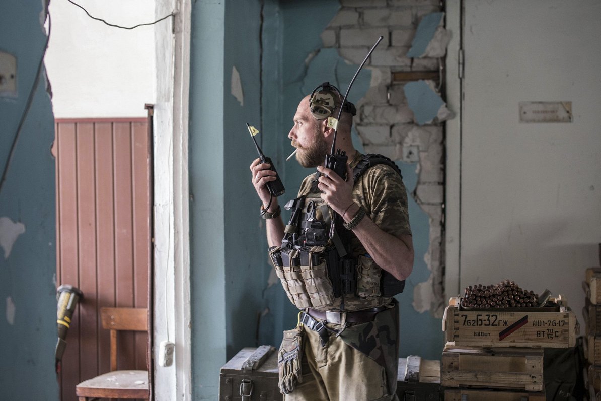 Ukrainas armijas karavīrs ar rācijām saņem informāciju par cīņām Severodoneckā