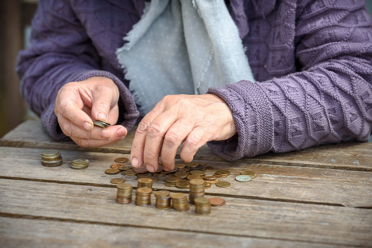 Veca sieviete skaita monētas