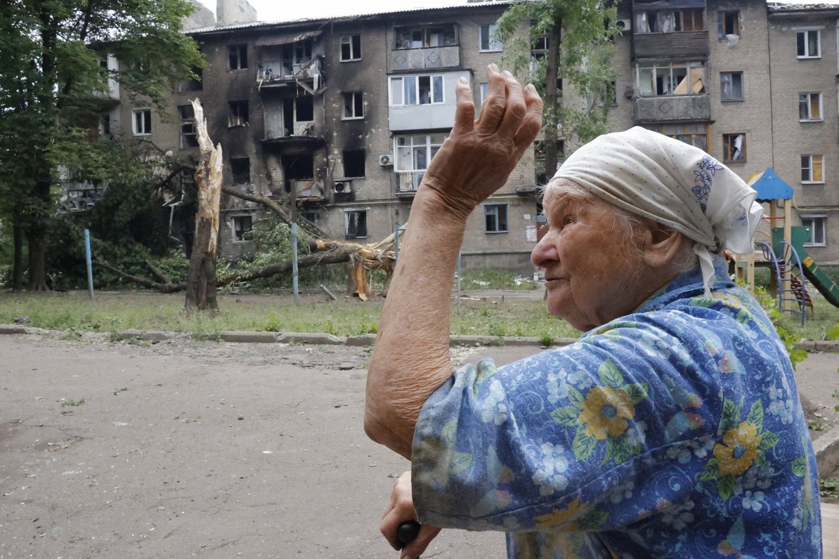 Sieviete pie karadarbībā izpostītas mājas separātistu kontrolētajā Doneckas pilsētā
