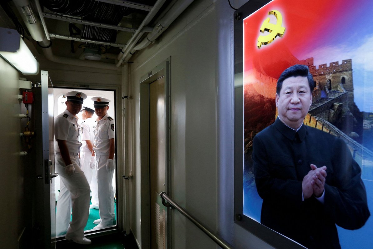 Ķīnas jūrnieki un attēls ar Ķīnas prezidentu Sji Dzjiņpinu.