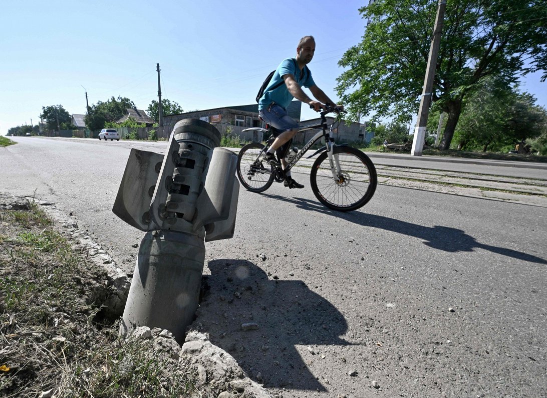 Doneckas apgabala pilsētā Kramatorskā riteņbraucējs brauc gar nesprāgušu Krievijas izšauto šāviņu