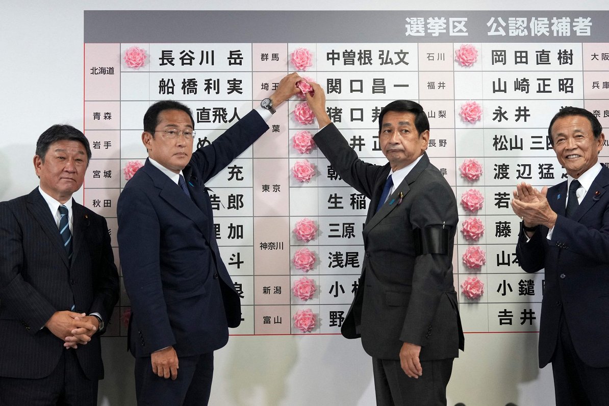 Japānas premjerministrs un  LDP vadītājs Fumio Kisida atzīmē ar sarkanu ziedu kandidātus, kuri, iesp...