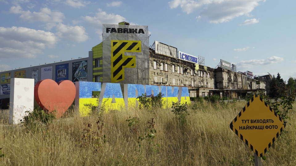 Разбитый российскими обстрелами шопинг-молл Fabrika в Херсоне. Надпись на переднем плане по-украинск...
