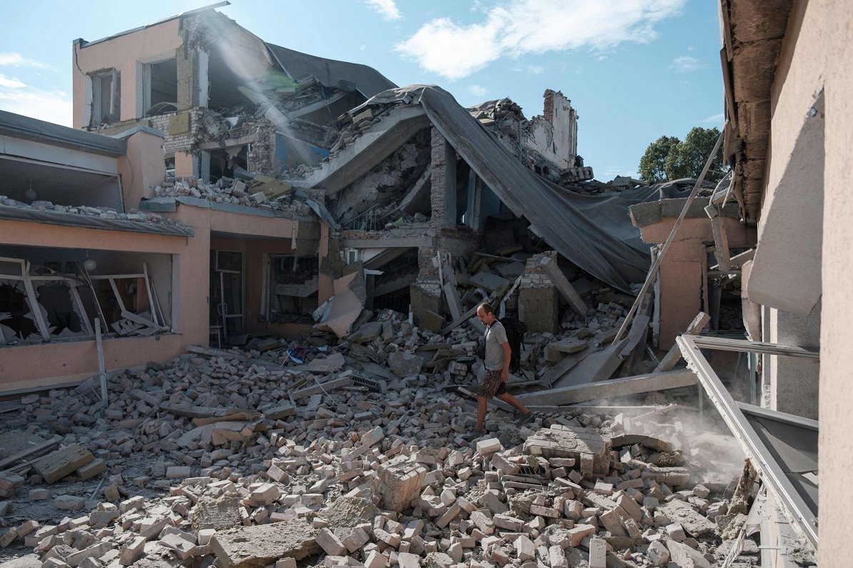 Учитель пробирается по развалинам школы, разрушенной в результате обстрела в Бахмуте Донецкой област...