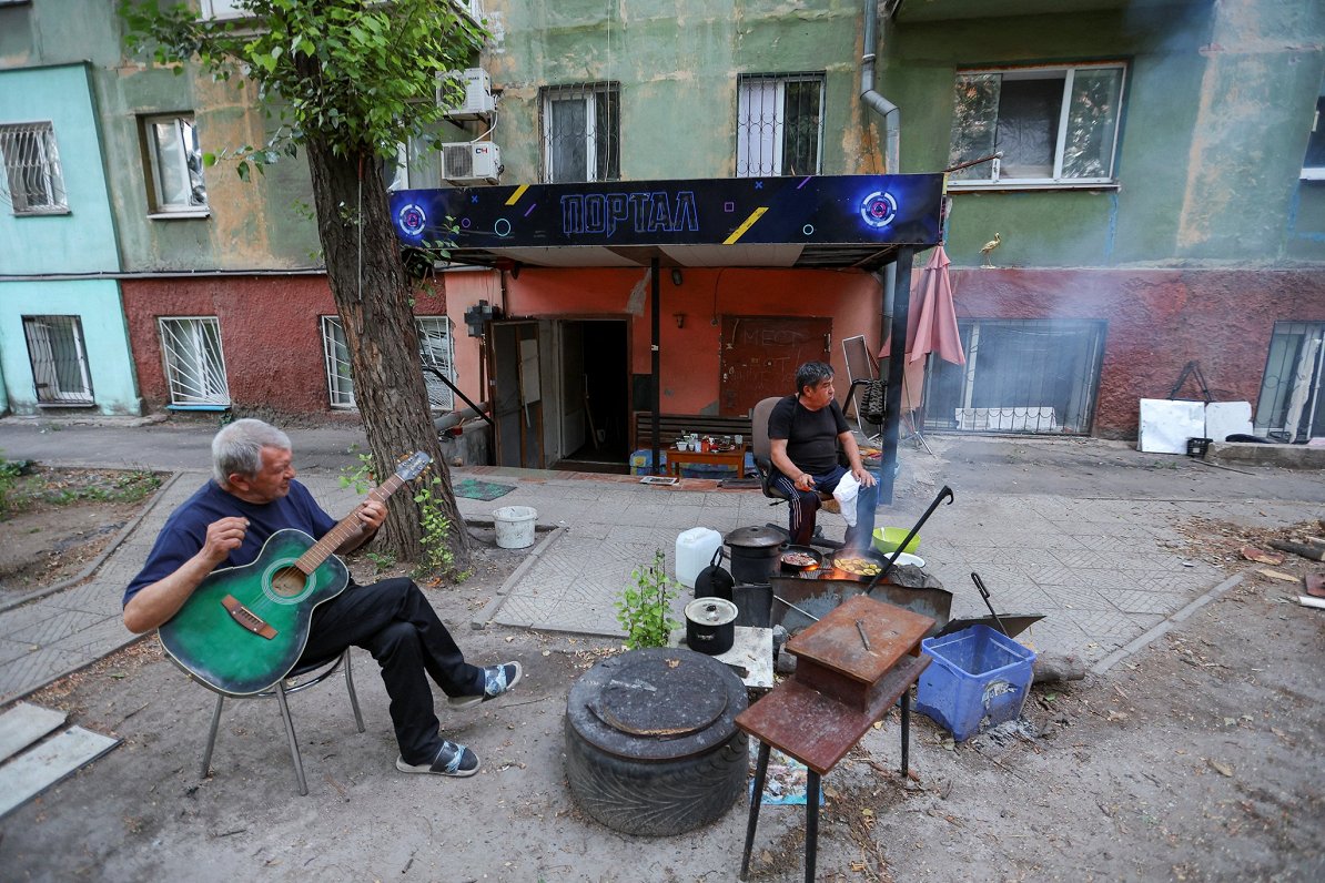 Krievijas spēku okupētās Mariupoles pilsētas iedzīvotājs Valentīns Marčenko spēlē ģitāru, kamēr viņa...