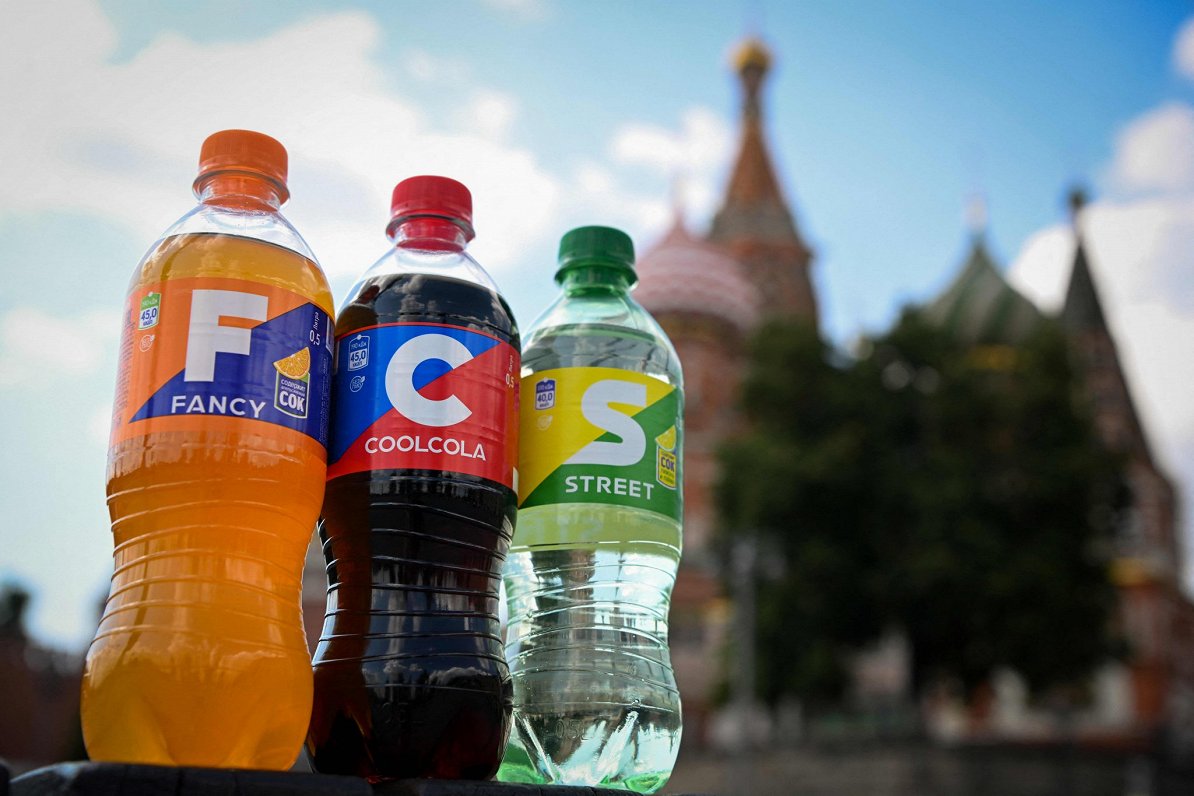 Лимонады, имитирующие оригинальную продукцию Coca-Cola Co., на фоне московского Кремля.