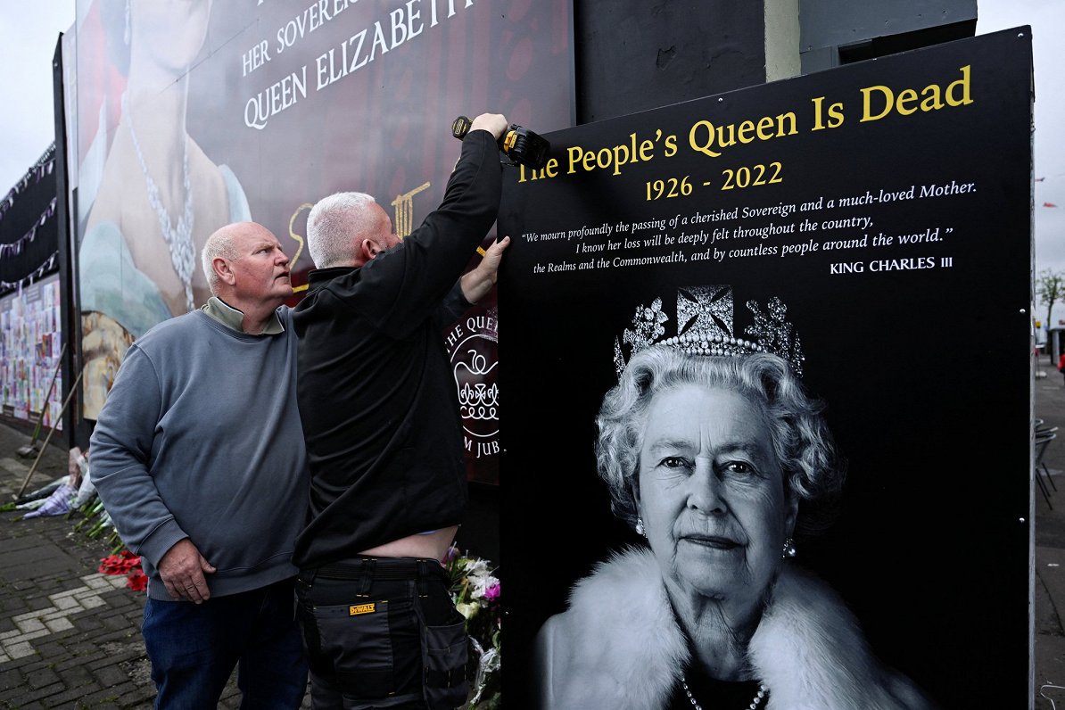 Vīri uzstāda plakātu Belfāstā, Ziemeļīrijā