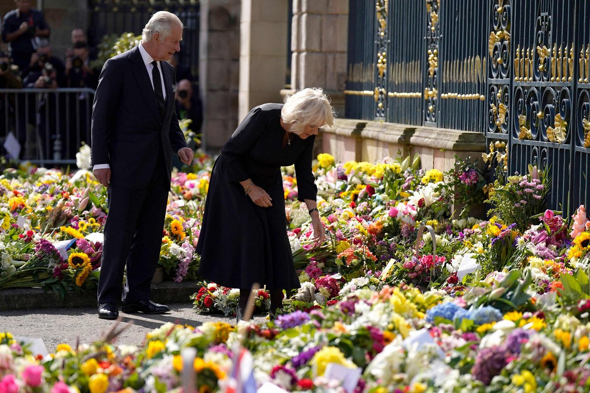 Lielbritānijas karalis Čārlzs III ar sievu Kamillu aplūko ziedus, ko Belfāstā sanesuši Ziemeļīrijas...